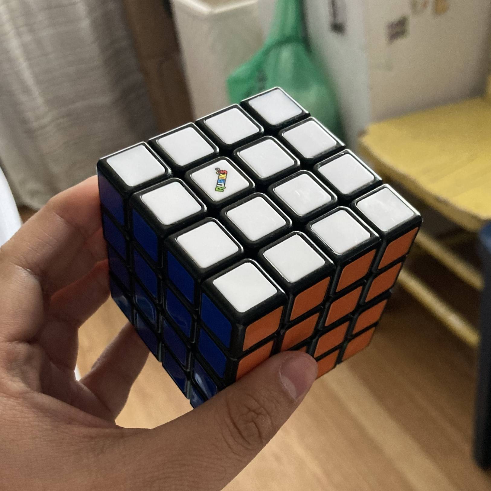 Me holding up my solved 4x4 Rubik's cube.